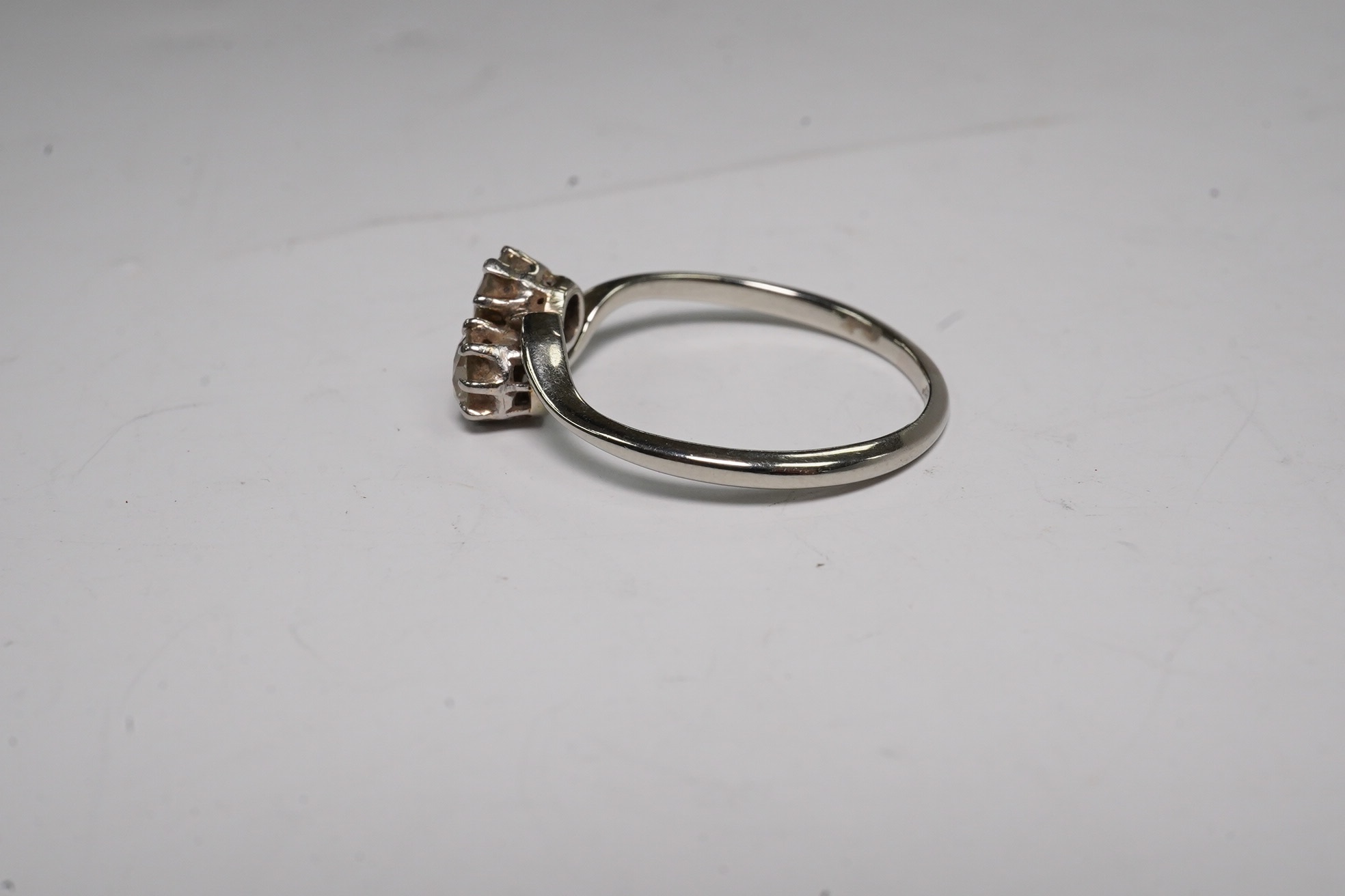 An 18ct, plat and two stone diamond set crossover ring, size O, gross weight 2.3 grams, Condition - fair to good